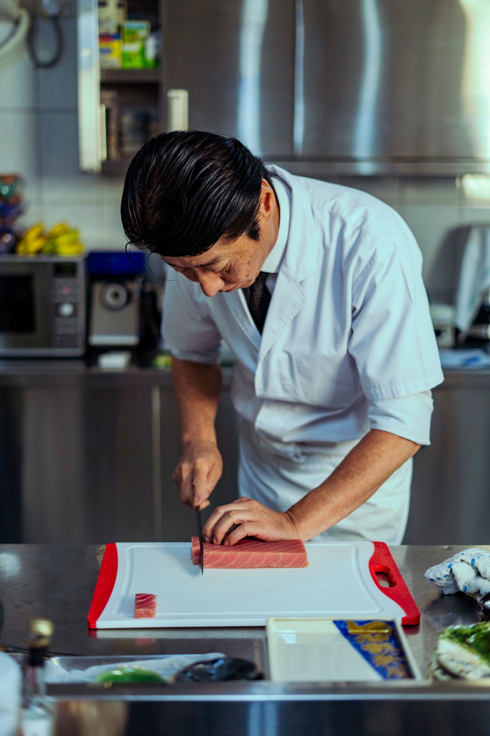 Sushi chef slicing bluefin tuna for a catered event Sushi chef slicing bluefin tuna for a catered event