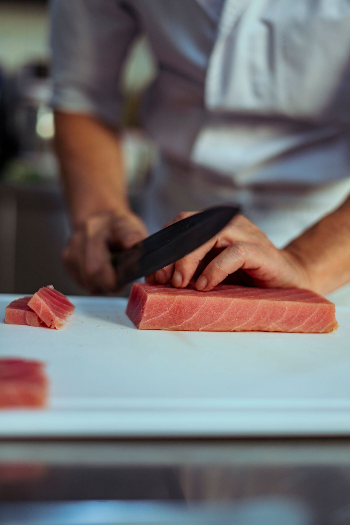 Chef slicing bluefin tuna for sashimi Chef slicing bluefin tuna for sashimi