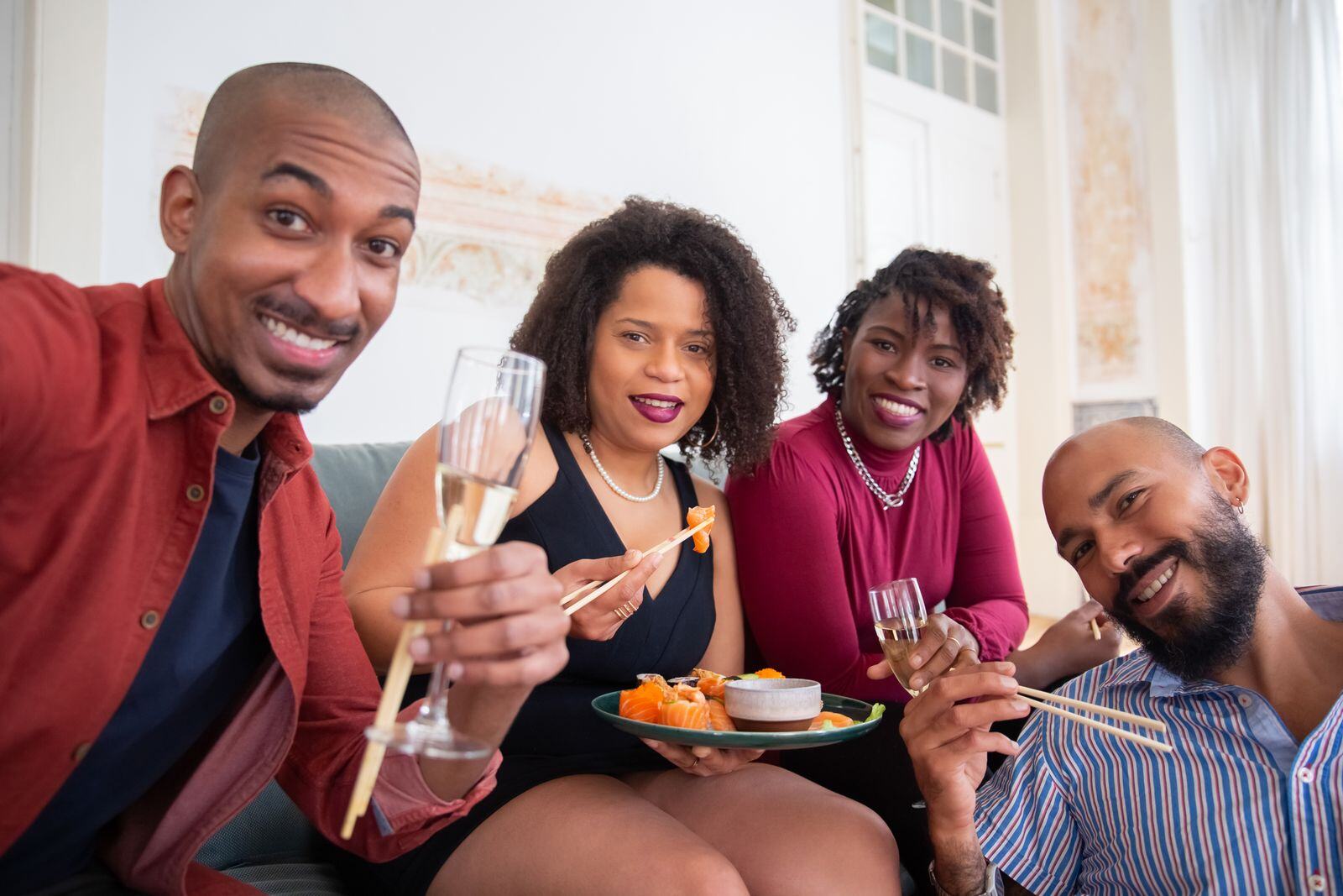 Friends enjoying sushi and champagne at a home party in Manhattan