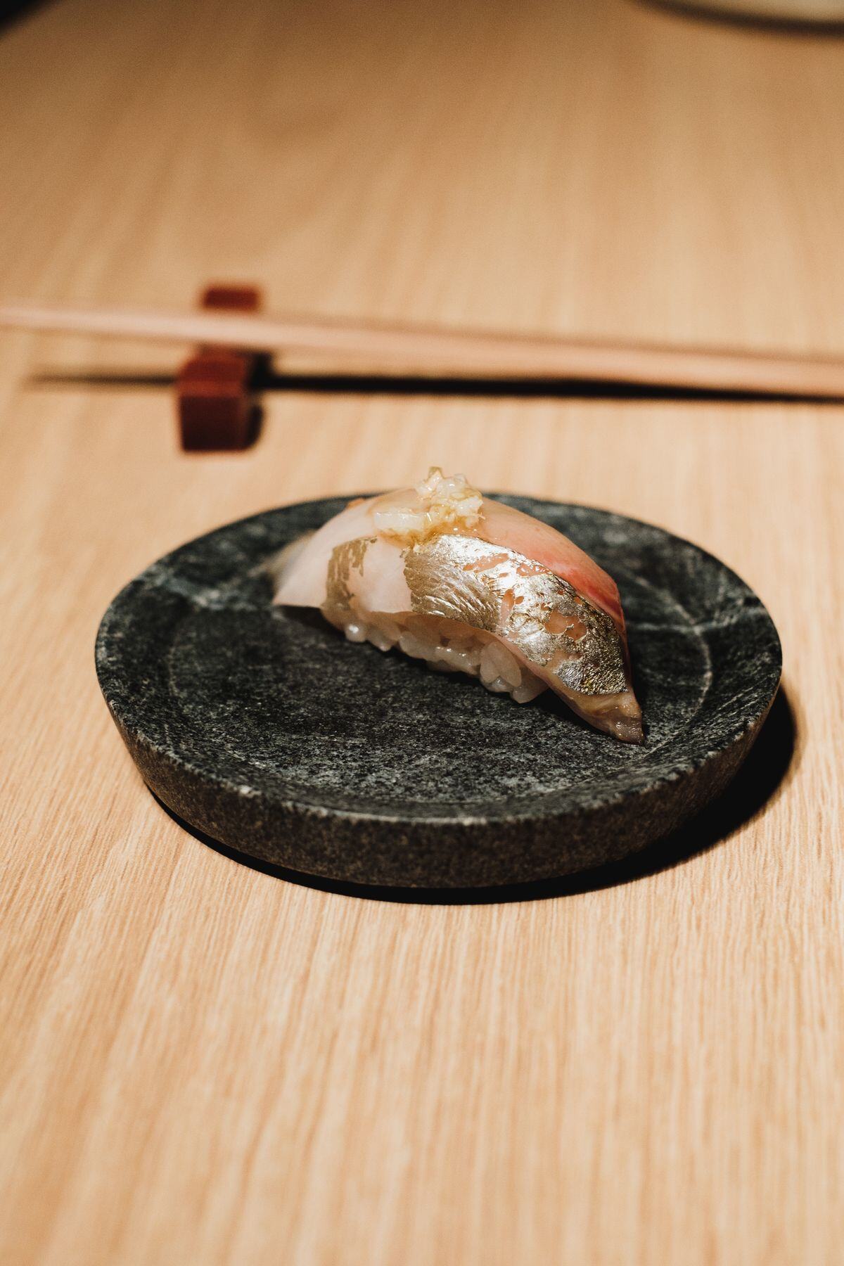 Single piece of nigiri served on a stone plate Single piece of nigiri served on a stone plate